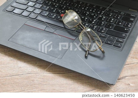 eye glass arranging on laptop computer on table eye glass arranging on laptop computer on table 140623450