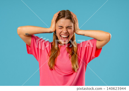 Angry woman yelling at camera with expressive face, covering ears with hands. Angry woman yelling at camera with expressive face, covering ears with hands. 140623944