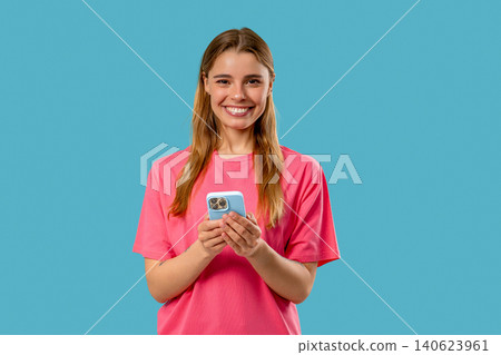 Pretty Woman Surfing Internet On Smartphone. Girl With Smile On Blue Background 140623961