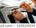 A car wrapping specialist applies a polyurethane film to the car. Detailer PPF 140624034