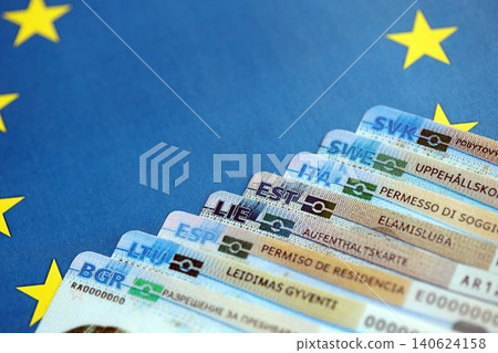 Permanent resident or residence permit cards lies on European Union flag. Paper specimen cards Permanent resident or residence permit cards lies on European Union flag. Paper specimen cards 140624158