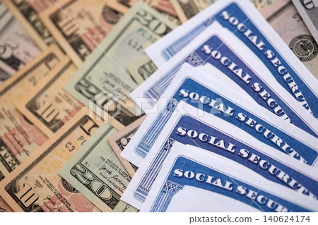 Social security number cards on many US dollar money bills Social security number cards on many US dollar money bills 140624174