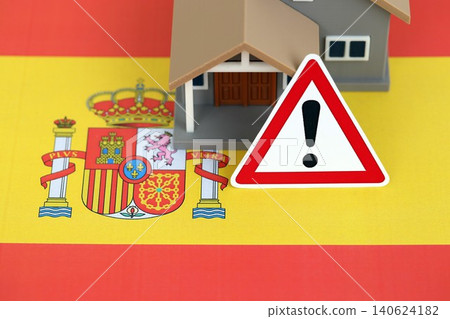 Residential house with alert sign on Spanish flag close up. Concept of Squatting in Spain Residential house with alert sign on Spanish flag close up. Concept of Squatting in Spain 140624182