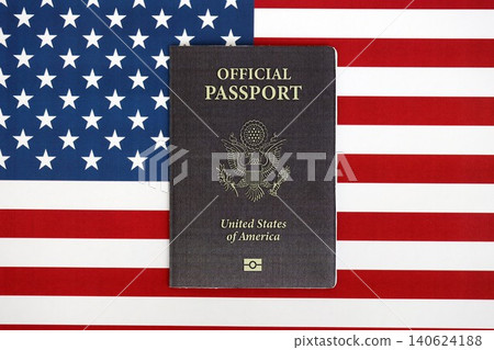 United States official passport book on US flag close up. Travel document on official banner United States official passport book on US flag close up. Travel document on official banner 140624188