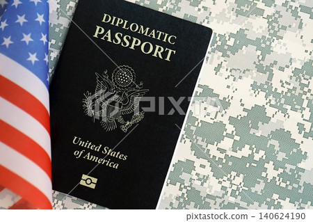 United States diplomatic passport book with US flag on camouflage uniform close up United States diplomatic passport book with US flag on camouflage uniform close up 140624190