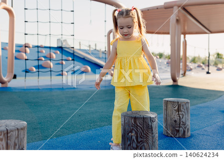 Child exploring playground outdoors with modern equipment Child exploring playground outdoors with modern equipment 140624234