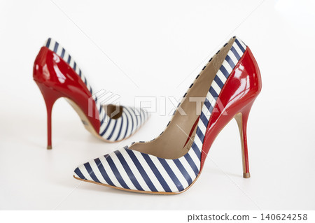 Pair of striped navy high heel shoes with red accents on white studio background Pair of striped navy high heel shoes with red accents on white studio background 140624258
