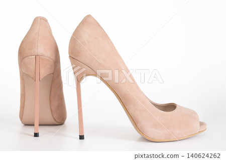 Fashion beige suede stiletto pumps with peep toe design on clean studio background Fashion beige suede stiletto pumps with peep toe design on clean studio background 140624262