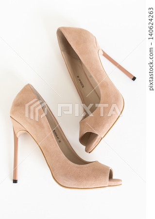 Stylish beige suede stiletto pumps with peep toe design on bright white backdrop 140624263