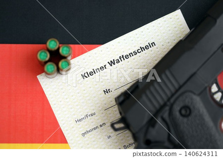 German light firearms license and handgun with bullets on Germany flag close up. Gun permit German light firearms license and handgun with bullets on Germany flag close up. Gun permit 140624311
