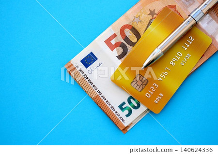 Credit card and pen with euro currency money bills banknotes on light blue background Credit card and pen with euro currency money bills banknotes on light blue background 140624336