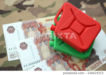 Petrol canister on russian roubles money bills on camouflage fabric. Concept of petroleum export Petrol canister on russian roubles money bills on camouflage fabric. Concept of petroleum export 140624353