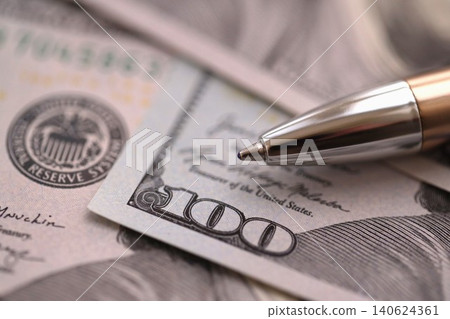 One hundred US dollar bills and silver pen close up. Concept of business calculating and accounting One hundred US dollar bills and silver pen close up. Concept of business calculating and accounting 140624361