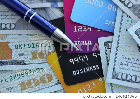 One hundred US dollar bills and silver pen with credit cards close up. Concept of business One hundred US dollar bills and silver pen with credit cards close up. Concept of business 140624369