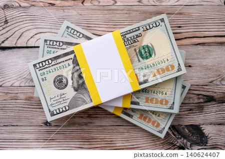 Three packs of ten thousand US dollar bills on wooden background. Packs of hundred dollar bills 140624407