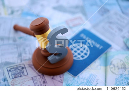Judgement gavel and paragraph symbol on passport pages full of colorful stamps after travel 140624462