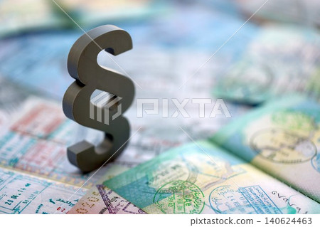Paragraph symbol on passport pages full of colorful stamps after travel and tourism Paragraph symbol on passport pages full of colorful stamps after travel and tourism 140624463