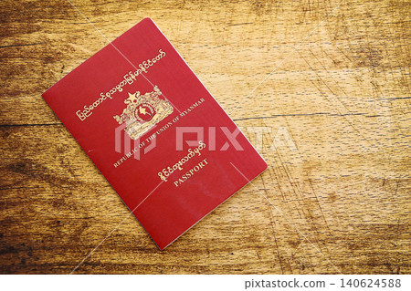 Myanmar passport on table close up. Official identification document book for citizens of Myanmar Myanmar passport on table close up. Official identification document book for citizens of Myanmar 140624588