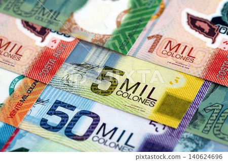 Costa Rican colon money bills pile on table. Costa Rica banknotes of CRC currency close up Costa Rican colon money bills pile on table. Costa Rica banknotes of CRC currency close up 140624696