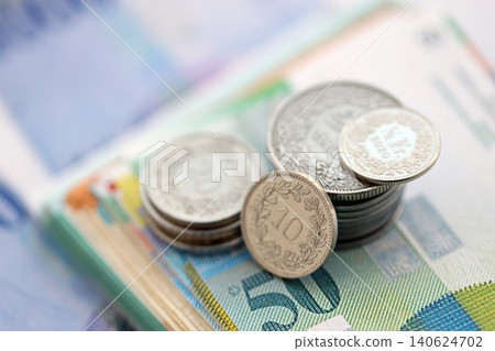 Swiss franc money bills and cent coins pile on table. Switzerland coins on banknotes of CHF currency 140624702