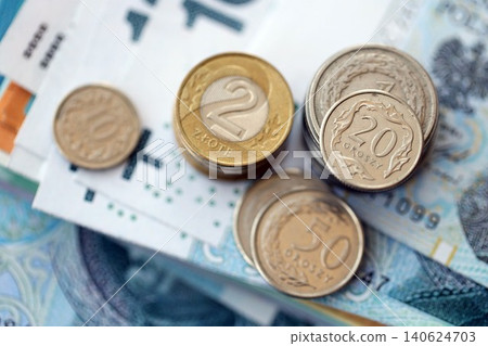 Polish zloty money bills and grosz coins pile on table. Poland coins on banknotes of PLN currency Polish zloty money bills and grosz coins pile on table. Poland coins on banknotes of PLN currency 140624703