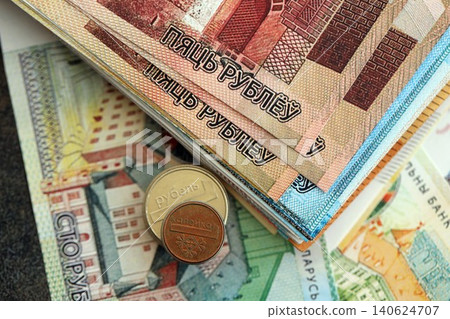 Belarusian ruble money bills and kopek coins pile. Belarus coins on banknotes of BYN currency Belarusian ruble money bills and kopek coins pile. Belarus coins on banknotes of BYN currency 140624707