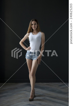 young beautiful woman on a dark background, full length studio shot young beautiful woman on a dark background, full length studio shot 140625203