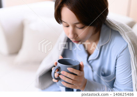 一個女人喝一杯熱飲料 140625486