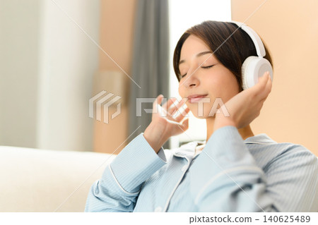 A woman enjoying music with headphones 140625489