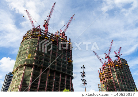 Low-angle view of cranes and steel structures of building construction with a blue sky background in Taipei, Taiwan. Low-angle view of cranes and steel structures of building construction with a blue sky background in Taipei, Taiwan. 140626037