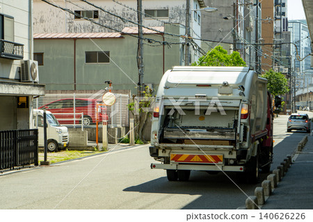 一輛垃圾車在辦公區作業的後視圖。 140626226