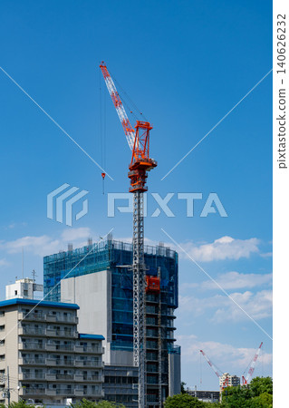 一個建築工地,一台塔式起重機,以及一片藍天。 一個建築工地,一台塔式起重機,以及一片藍天。 140626232