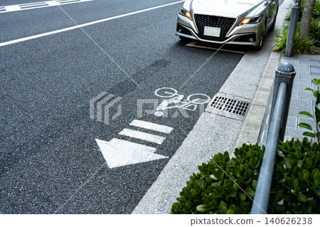 路面上畫著自行車導航線，後面停著一輛汽車。 140626238