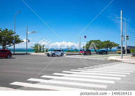 這是沖繩縣宇流麻市海中路與綾橋路公園交叉口的一景。人行道上可以欣賞到藍天和大海的景色。 這是沖繩縣宇流麻市海中路與綾橋路公園交叉口的一景。人行道上可以欣賞到藍天和大海的景色。 140626413