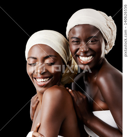 Black women, head wrap and beauty portrait with smile, skincare and cosmetics in studio with bonding. Girl friends, happy and African scarf with wellness and skin glow with makeup and dark background Black women, head wrap and beauty portrait with smile, skincare and cosmetics in studio with bonding. Girl friends, happy and African scarf with wellness and skin glow with makeup and dark background 140626556