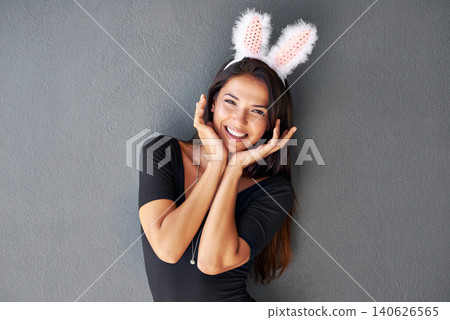 Bunny ears, happy or portrait of woman with fashion isolated on wall or grey background with style. Funny joke, confident lady or casual female person in studio with pride, smile and trendy clothes Bunny ears, happy or portrait of woman with fashion isolated on wall or grey background with style. Funny joke, confident lady or casual female person in studio with pride, smile and trendy clothes 140626565