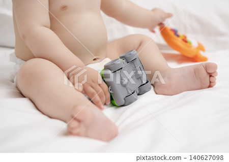 Close-up of baby hands holding and playing with a colorful toy concrete mixer truck Close-up of baby hands holding and playing with a colorful toy concrete mixer truck 140627098