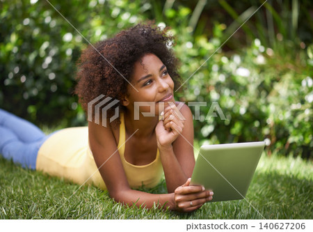 African woman, tablet and relax on grass with thinking, memory and smile for post on web blog. Girl, digital touchscreen and happy in backyard, garden and outdoor with app for social media in Brazil African woman, tablet and relax on grass with thinking, memory and smile for post on web blog. Girl, digital touchscreen and happy in backyard, garden and outdoor with app for social media in Brazil 140627206