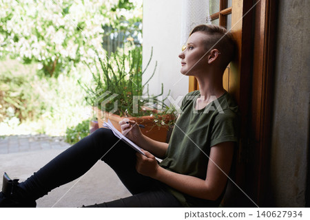 Woman, writing notes and thinking on floor in home for brainstorming, reflection and serious by garden. Dream, notepad and student with creative ideas, inspiration and planning to do list on journal 140627934