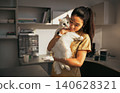 Gentle Vet Cradles Large White Cat Close to Her Face in Soft Natural Clinic Light 140628321