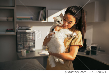 Gentle Vet Cradles Large White Cat Close to Her Face in Soft Natural Clinic Light 140628321