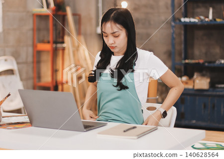 Female artist wears black hat posing near picture indoor the studio 140628564