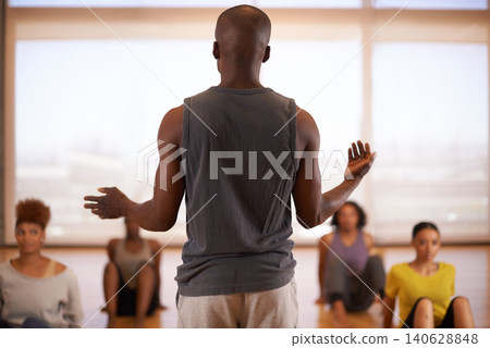 People, dancer and instructor with class of students in fitness, workout or pilates at the studio. Rear view of personal trainer talking to group in body warm up or stretching for health and wellness People, dancer and instructor with class of students in fitness, workout or pilates at the studio. Rear view of personal trainer talking to group in body warm up or stretching for health and wellness 140628848