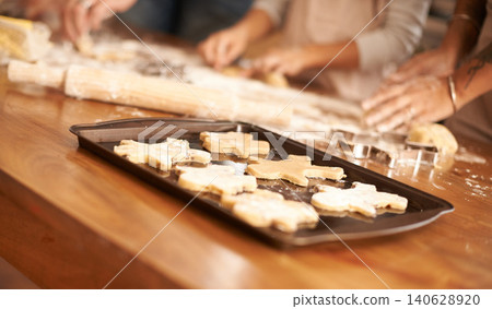 Bake, gingerbread man biscuits and people in kitchen of home, closeup for cooking or pastry preparation. Food, baking or cookies with hands of family at wooden counter in apartment for snack recipe 140628920