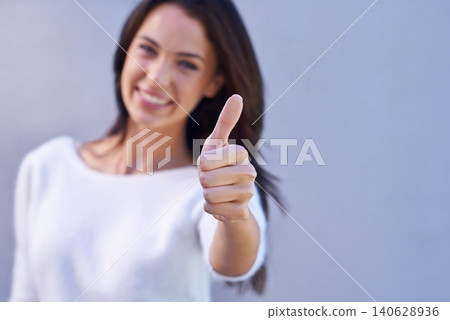 Thumbs up, happy and portrait of woman with success, winner and goal reached isolated on gray background. Hand, female person and gesture for yes, thank you and achievement with smile in studio Thumbs up, happy and portrait of woman with success, winner and goal reached isolated on gray background. Hand, female person and gesture for yes, thank you and achievement with smile in studio 140628936