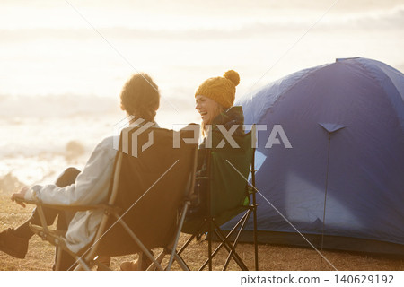 Happy, camping and couple by tent on vacation, adventure or holiday in nature for travel. Smile, love and young man and woman talking, bonding and relaxing outdoor for weekend trip by seaside. 140629192
