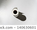 Top view of a white paper towel roll standing on a light gray surface 140630601