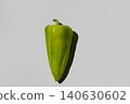 Single fresh green pepper with shadow on a plain grey background 140630602