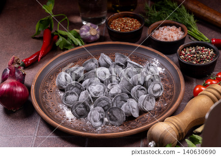Black pelmeni dumplings on plate with spices and ingredients 140630690