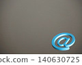 A still life/internet communication concept featuring an "@" symbol clip against a metal plate background. 140630725